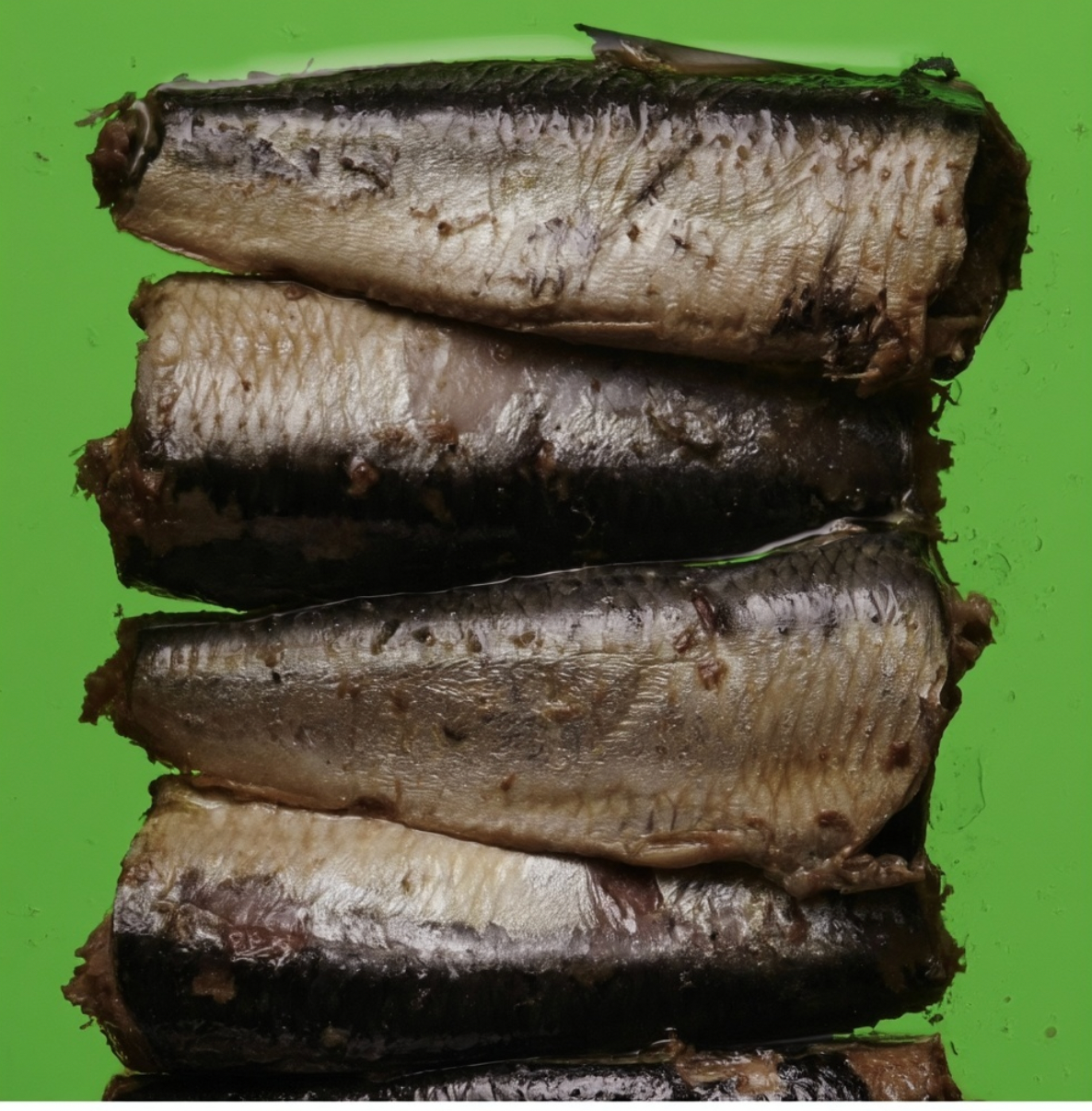 Sardines à l’huile empilées sur un fond vert
